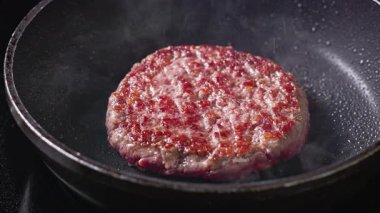 Şef biber değirmeninden kıyma köftesine kadar taze biber serpiyor. Sıcak tavada et, yemek yakın plan.