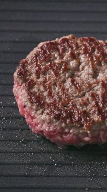 Taze kıymalı burger köftesi sıcak elektrikli ızgara yüzeyinde pişiyor, yemek yakın plan.