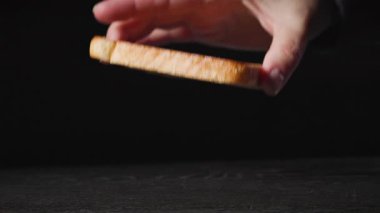 Bir aşçı, kulüp sandviçi yapmak için siyah ahşap tahtaya taze ekmek dilimi koymuş. Yemek yakın plan. Sağlıklı yemek yapma süreci