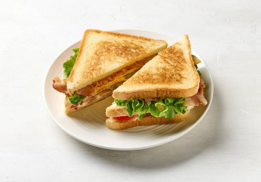 Beyaz tabakta yarı yarıya sandviç.