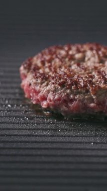 Taze kıymalı burger köftesi sıcak elektrikli ızgara yüzeyinde pişiyor, yemek yakın plan.