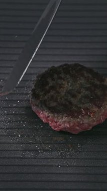 Aşçı et kıyma etrafında döner sıcak siyah elektrikli ızgara yüzeyinde pişirme, yiyecek yakın çekim