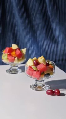 Mavi arka planda bir kase taze meyve salatası, yakın plan yemek, sağlıklı beslenme.