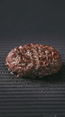 Taze kıymalı burger köftesi sıcak ızgarada pişiyor, yemek yakın plan.