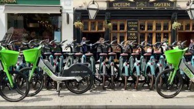 Londra, İngiltere - 18 Mayıs 2025: Kiralık bisikletli Londra Caddesi 'nin güzel manzarası ve güneşli bir günde arka planda geleneksel Pub, Lyceum Tavern