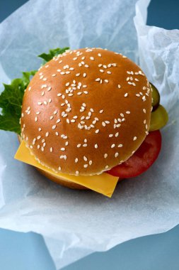 Ambalaj kağıdındaki taze lezzetli burger, üst kattaki yakın plan.