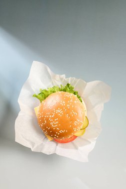 Yaratıcı arka planda taze, lezzetli bir burger.