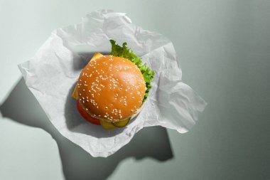 Gri arka planda taze lezzetli burger, üst manzara.