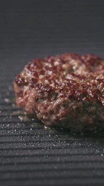Taze kıymalı burger köftesi sıcak ızgarada pişiyor, yemek yakın plan.