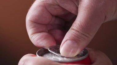 İnsan eli alüminyum içecek kutusu. Metal kavanozda yakın plan için. Soda kutusu açılıyor.