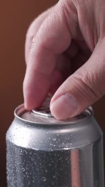 İnsan eli alüminyum içecek kutusu. Metal kavanozda yakın plan için. Soda kutusu açılıyor.