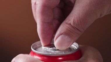 İnsan eli alüminyum içecek kutusu. Metal kavanozda yakın plan için. Soda kutusu açılıyor.