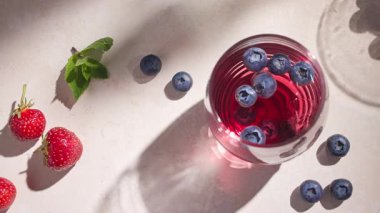 Buzlu ve taze böğürtlenli kırmızı soğuk içecek bardağına yakın plan.