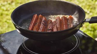 Açık hava yemekleri. Haşlanmış havuçları sıcak tavada pişirmek yağlı, bahçede lezzetli yemekler pişirmek için yakın plan, açık hava.