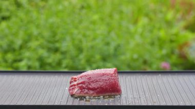 Açık hava yemekleri. Pişirmek taze çiğ sığır filetosu hazırlamak yağlı ve baharatlı biftek ve sıcak ızgara tavada lezzetli yemek yapmak için bahçe, yemek yakın plan, açık hava doğal ışık