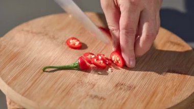 Şef sağlıklı bir yemek hazırlamak için panoya taze kırmızı kırmızı biber koyar. Açık hava yemekleri, yakın mesafe yemekleri.