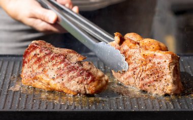 Sıcak elektrikli ızgara yüzeyinde taze ızgara sığır eti ve biftek.