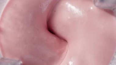 Çilekli ve muzlu, pembe milkshake karışımı. Üst Manzara. Ağır çekim. Sağlıklı protein smoothie içecek konsepti, yiyecek yakın çekim