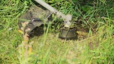 Kesici çimenleri yavaş çekimde biçer.