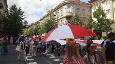 Vilnius, Litvanya - 1 Temmuz 2023: Eşcinsel geçit Vilnius gururu, neşeli insanlar gökkuşağı bayraklarıyla sokaklarda yürüyor