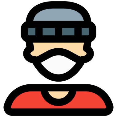 Yüz maskesi ve şapka takan genç bir delikanlı.