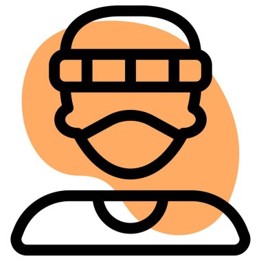 Yüz maskesi ve şapka takan genç bir delikanlı.