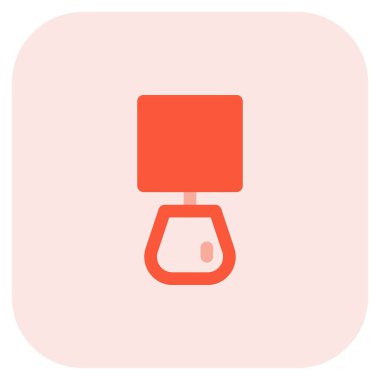 Yatağın kenarında duran şık gece lambası.