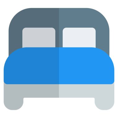 Yastıklı ve yatak başlıklı tahtadan bir yatak..