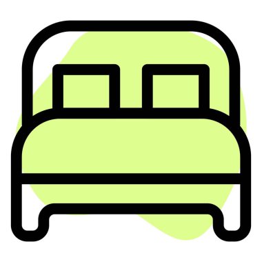 Yastıklı ve yatak başlıklı tahtadan bir yatak..