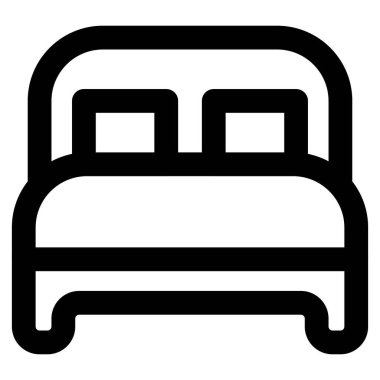 Yastıklı ve yatak başlıklı tahtadan bir yatak..