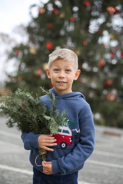 Cute little boy in Christmas sweater. Traditional city outdoors christmas