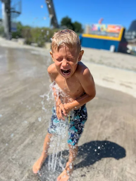 スプリンクラーの水の流れを楽しんでいる面白い赤ちゃんの男の子 — ストック写真