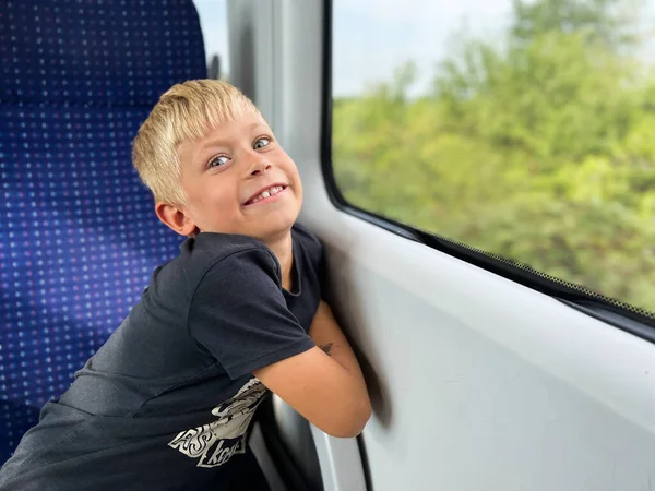 男孩坐火车旅行 坐在窗边向外看 — 图库照片