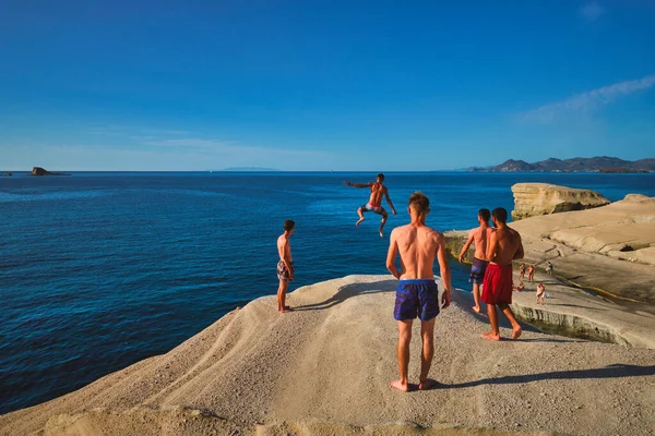 Sarakiniko Greece May 2019 Young Tourists Jump White Rocks Cliff — Stock Photo, Image