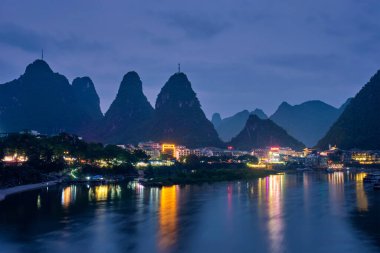 Yangshuo şehrinin manzarası Li nehrinin arka planında dramatik karst dağ manzarasıyla aydınlandı. Yangshuo, Çin