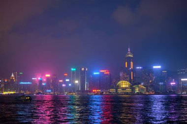 Hong KONG, ÇİN - 28 Nisan 2018: Hong Kong gökdelenleri Victoria Limanı üzerindeki şehir merkezi gökdelenleri turist botları ile aydınlatıldı. Hong Kong, Çin