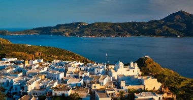 Milos adasındaki Plaka köyü manzarası. Günbatımında geleneksel Yunan beyaz evleri var. Plaka kasabası, Milos Adası, Yunanistan