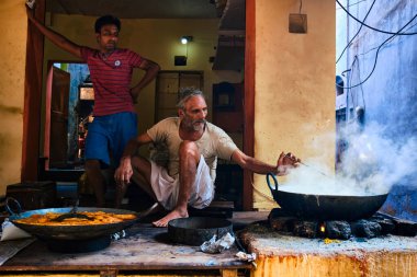 Pushkar, Hindistan - 7 Kasım 2019: Hindistan 'ın Rajasthan kentinde, Pushkar, Rajasthan caddesinde, kaşık tatlı ve haham tatlısı, yoğunlaştırılmış süt tabanlı yemekle karıştırılmış sokak yemekleri tezgahı aşçısı