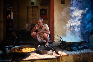 Pushkar, Hindistan - 7 Kasım 2019: Pushkar, Rajasthan, Hindistan 'da tatlı puri ve haham tatlısı, yoğunlaştırılmış süt tabanlı yemek pişirirken sokak yemekleri tezgahı aşçısı