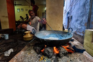 Pushkar, Hindistan - 7 Kasım 2019: Hindistan 'ın Rajasthan kentinde, Pushkar, Rajasthan caddesinde, kaşık tatlı ve haham tatlısı, yoğunlaştırılmış süt tabanlı yemekle karıştırılmış sokak yemekleri tezgahı aşçısı