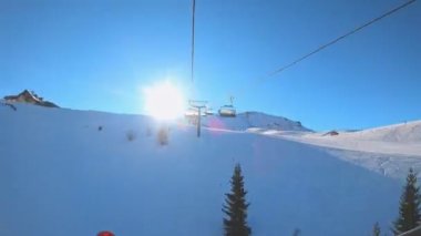 Kablolu sandalyede kayak kaldırmanın birinci şahıs bakış açısı FPV 'nin hızlı ileri etkisi alp kayağı için yükselir. Dolomitler 'de kayak yapan insanlarla kayak pisti. Kayak alanı Belvedere. Canazei, İtalya