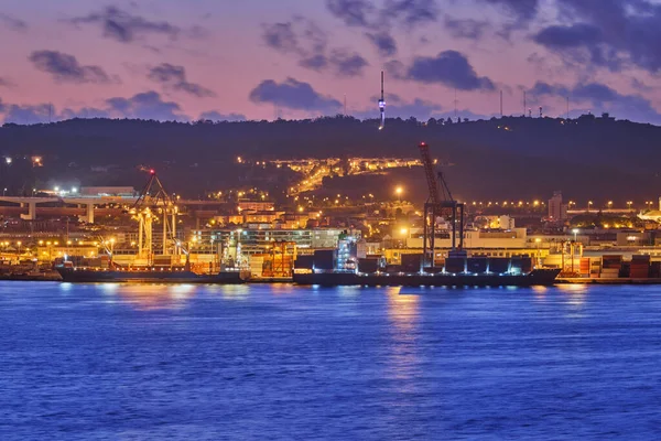 タガス川の上の夕暮れ時にポートクレーンと海のコンテナ船とリスボン港の眺め ポルトガルのリスボン — ストック写真