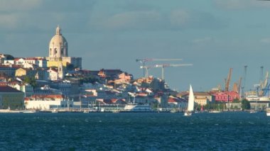 Almada 'dan Tagus nehrinin üzerindeki Lizbon manzarası. Günbatımında yatlarla turist botları. Lizbon, Portekiz