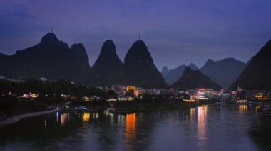 Yangshuo şehrinin manzarası Li nehrinin arka planında dramatik karst dağ manzarasıyla aydınlandı. Yangshuo, Çin. Yatay kamera tavası