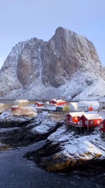 Lofoten Adaları 'ndaki Hamnoy balıkçı köyü, Norveç' te kırmızı rorbu evleriyle. Kışın yağan karla