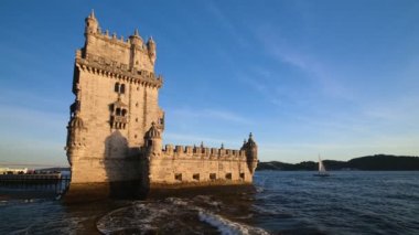 Belem Kulesi veya St Vincent Kulesi - Lisboa 'nın ünlü turizm merkezi - Tagus Nehri Tejo kıyısında gün batımında turist botlarıyla. Lizbon, Portekiz