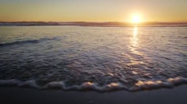 Fonte da Telha sahilinde dalgalanan dalgalarla Atlantik Okyanusu 'nun batışı, Costa da Caparica, Portekiz