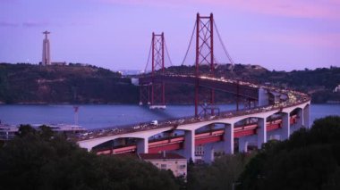 Lizbon manzarası Miradouro do Bairro do Alvito turist bakış açısı Tagus nehri, 25 Nisan Köprüsü trafiği ve akşam alacakaranlığında Kral İsa heykeli. Lizbon, Portekiz