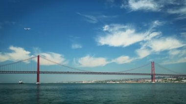 Lizbon 'un ünlü turistik beldesi 25 de Abril Köprüsü' nün Tagus nehri üzerindeki Setubal Yarımadası 'nda Lisboa' yı Almada 'ya bağlayan tekne yatları ve uçan uçaklar. Lizbon, Portekiz
