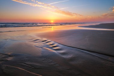 Fonte da Telha sahilinde dalgalanan dalgalarla Atlantik Okyanusu 'nun batışı, Costa da Caparica, Portekiz
